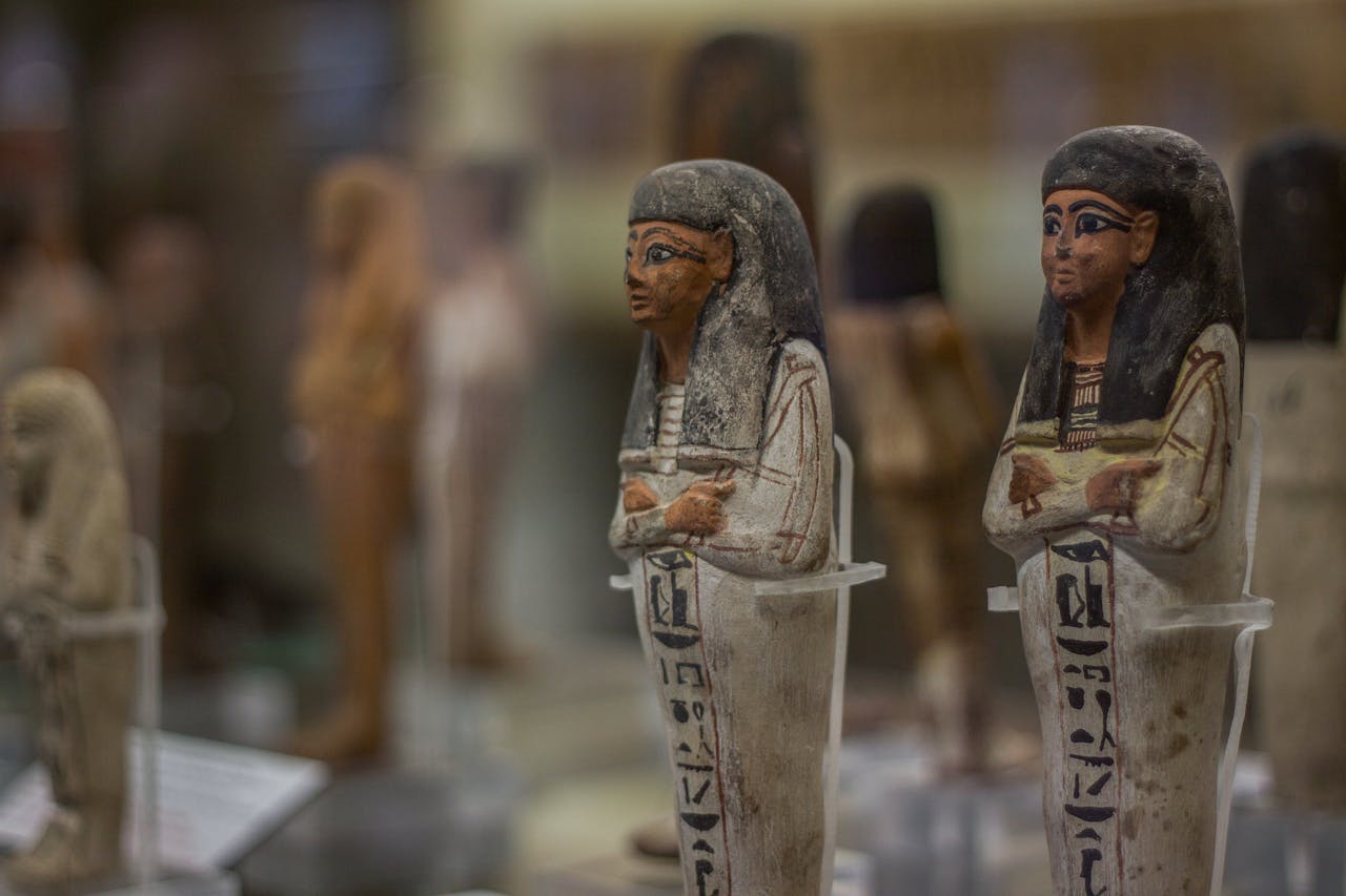 Detailed view of ancient Egyptian figurines on display in a Turin museum.